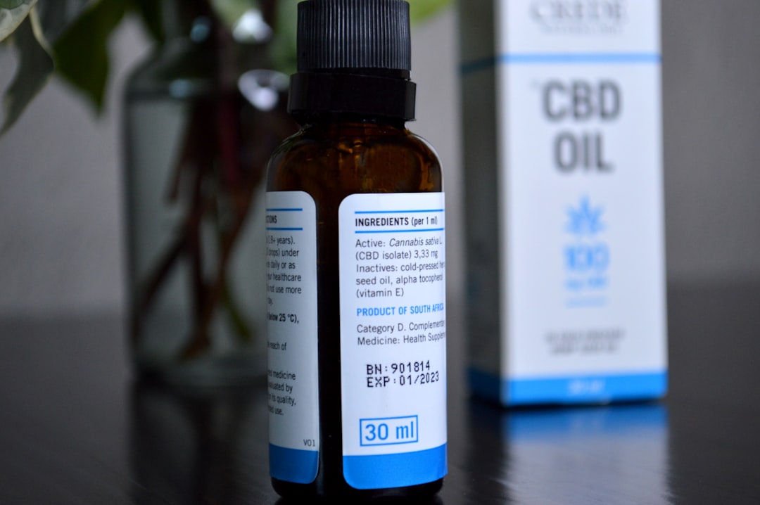 Gouttes d'huile CBD tombant d'un compte-gouttes dans un verre d'eau