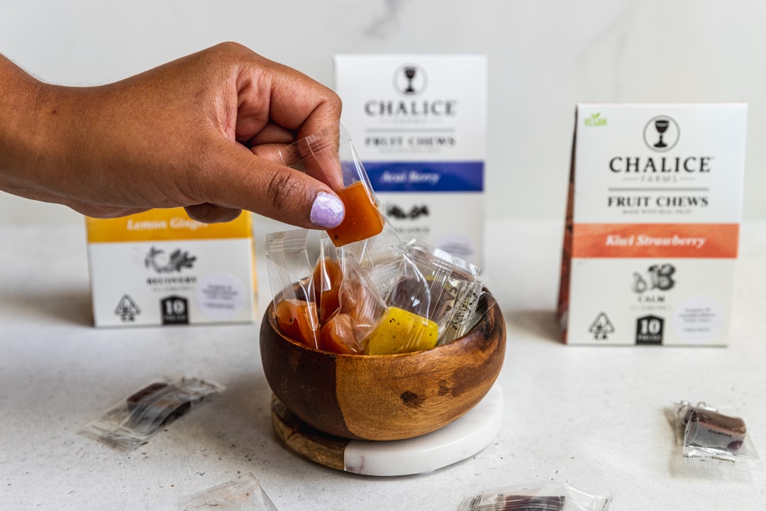 Assortiment de produits CBD comestibles (bonbons, chocolats, infusions) sur une étagère de magasin, menacés par la loi