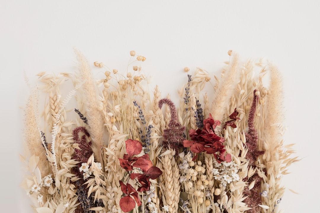 Arreglo decorativo de flores de cáñamo CBD junto a velas aromáticas y elementos naturales en un salón acogedor.
