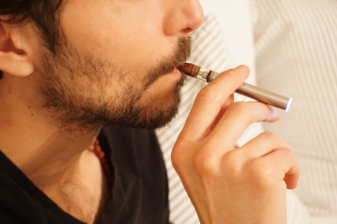 Persona relajándose mientras vapea un e-líquido CBD, con un fondo suave y natural que transmite calma.