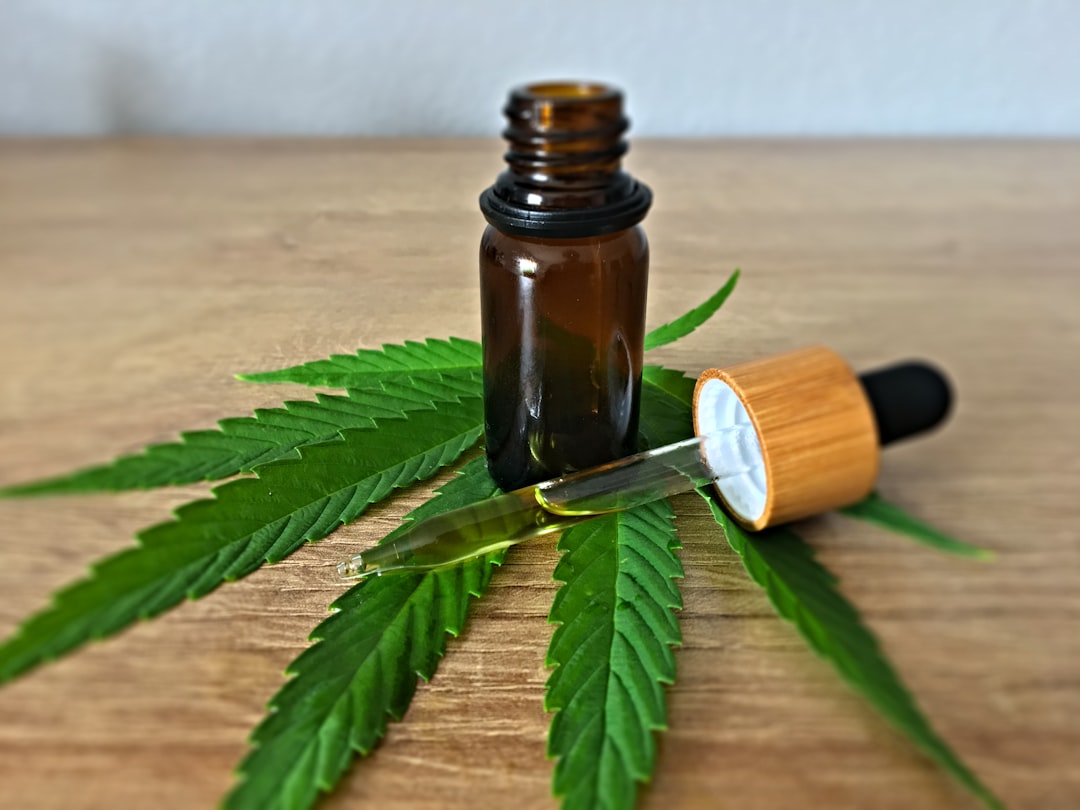 Primer plano de una mano sosteniendo un vaporizador con e-líquido de CBD, mostrando la etiqueta de concentración en miligramos.