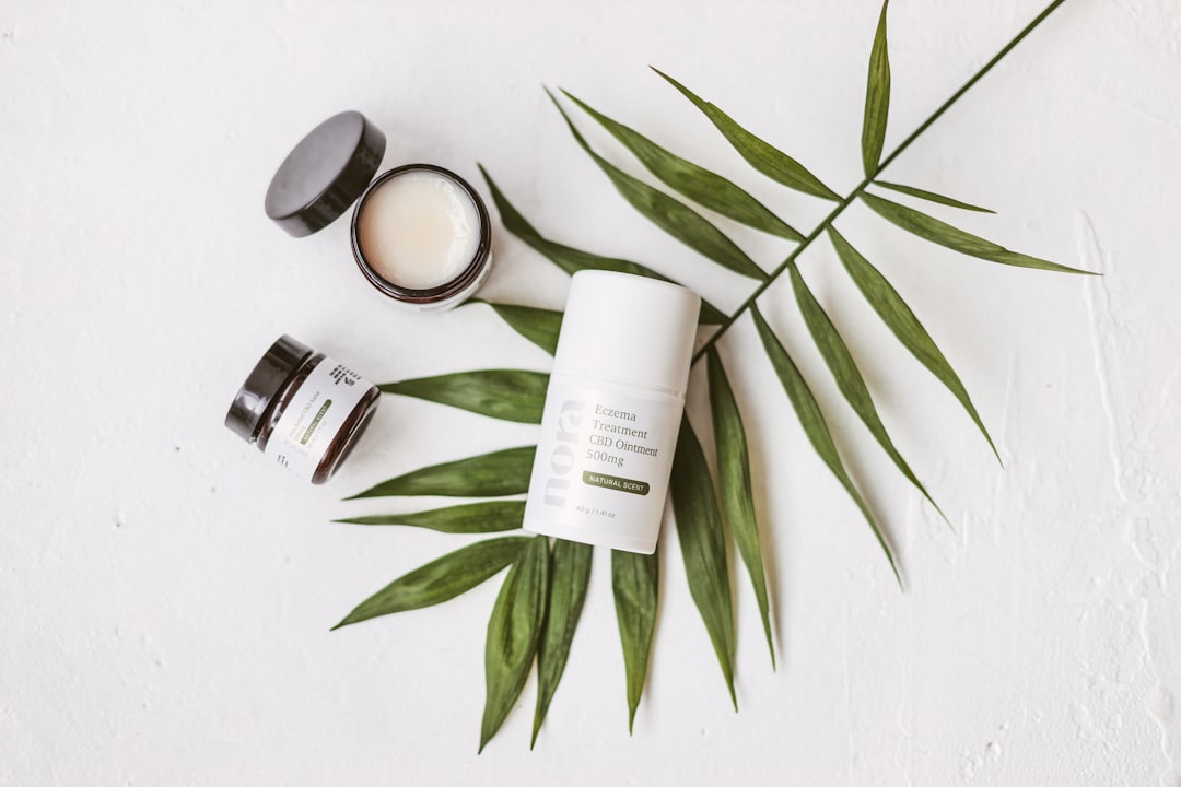 Un flacon de cosmétique CBD posé sur des feuilles de chanvre, illustrant les produits de beauté et le bien-être naturel.