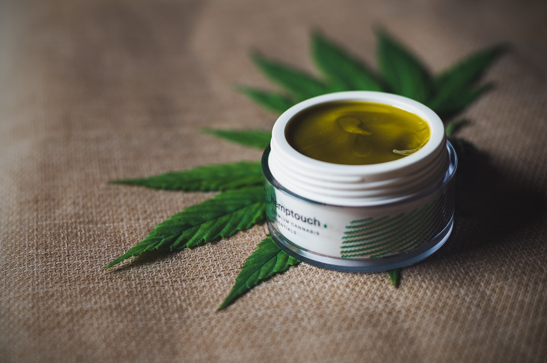 Bálsamos y cremas de CBD de diferentes concentraciones sobre una mesa de madera, simbolizando la guía para elegir la potencia tópica.