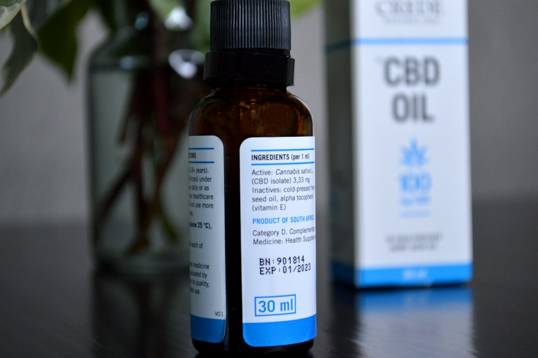 Une bouteille d'huile de CBD étiquetée 'objet de collection' posée sur une table en bois, soulignant la vente illégale de CBD alimentaire en France.