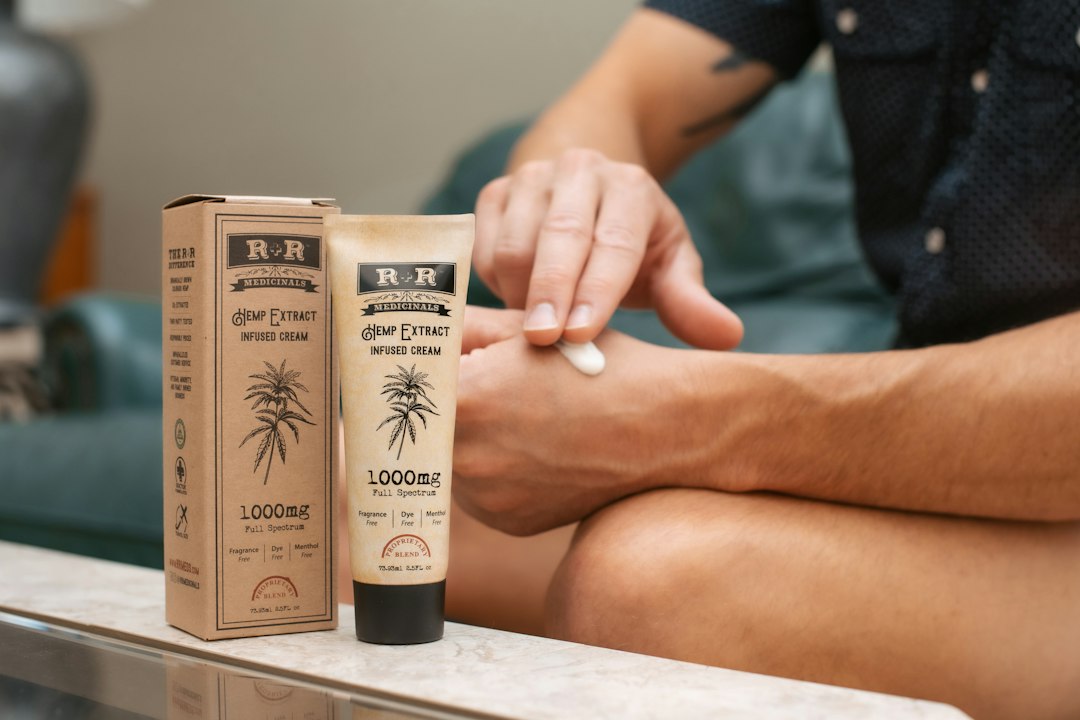 Mujer aplicando crema de CBD amplio espectro en la mano, mostrando su uso para la piel sensible y el bienestar.